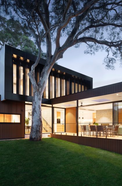 Symbolbild - modernes großes Haus beleuchtet bei Nacht mit Garten und Terrasse